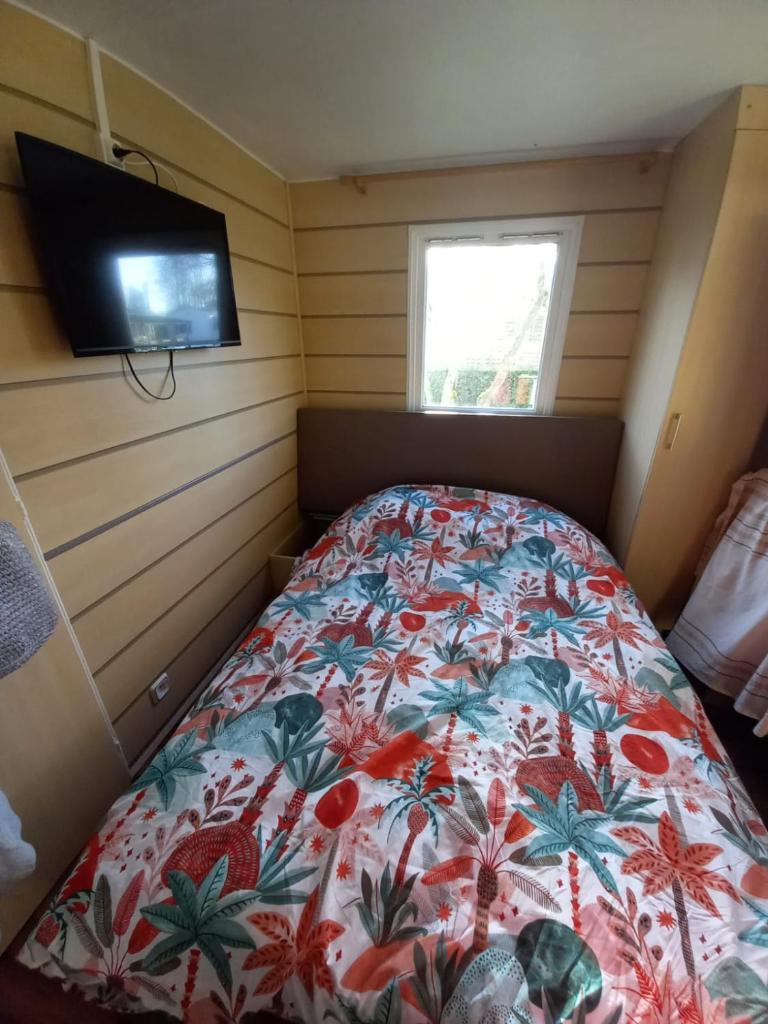 une chambre avec un lit avec un couvre-lit fleuri dans l'établissement Mobilhome EUROPA PARK, à Boofzheim
