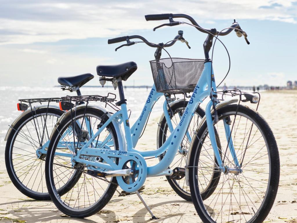 - un vélo bleu garé sur la plage dans l'établissement Hotel Bahia, à Lignano Sabbiadoro