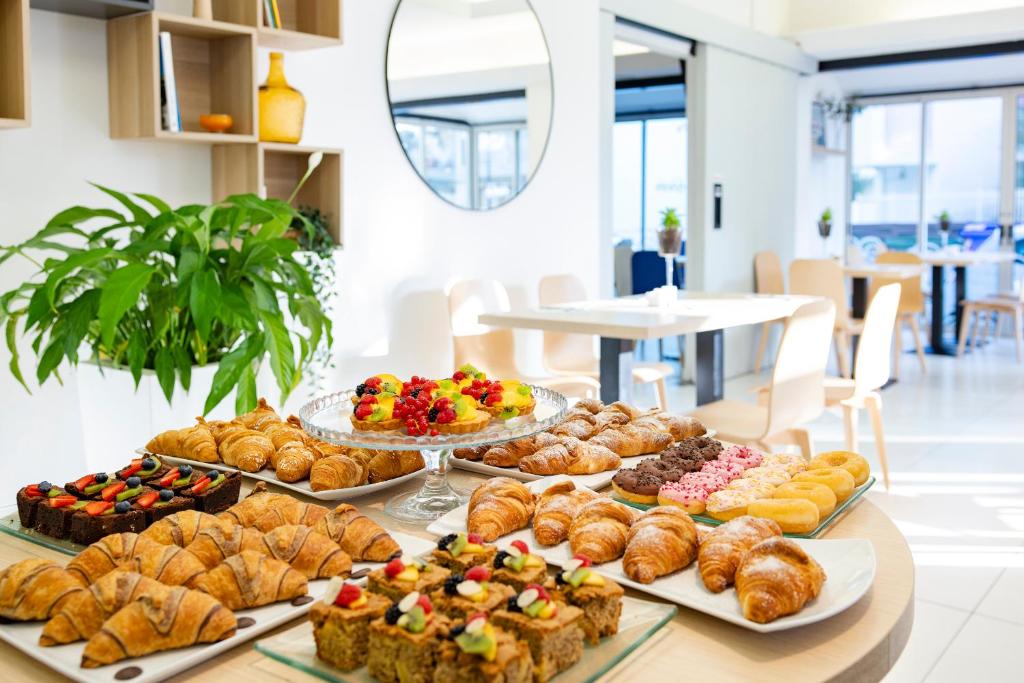 une table remplie de différents types de pâtisseries et de desserts dans l'établissement Hotel Bahia, à Lignano Sabbiadoro