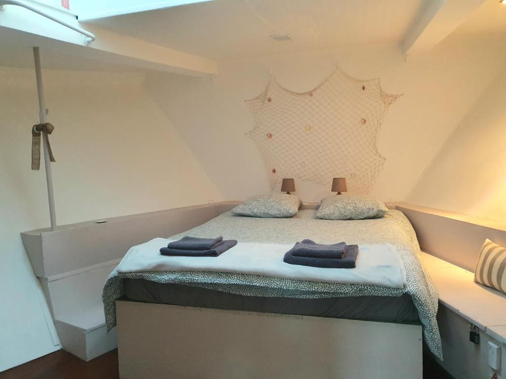 une chambre avec un lit avec deux serviettes dessus dans l'établissement EXIGEHOME - Péniche 120 m2 en bord de Seine calme et verdoyant, à Le Port-Marly