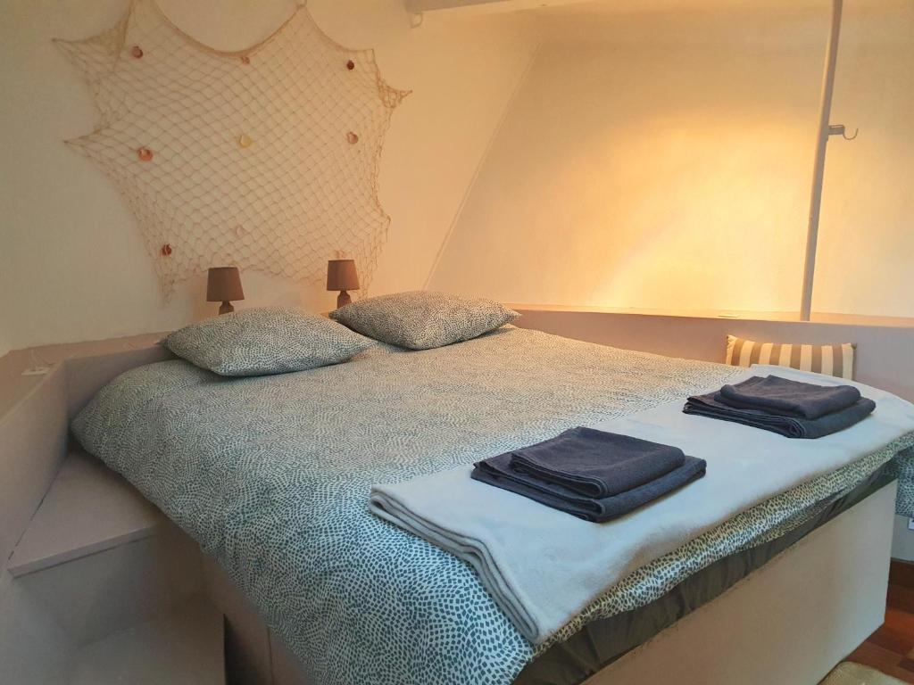 une chambre avec un lit avec deux serviettes dessus dans l'établissement EXIGEHOME - Péniche 120 m2 en bord de Seine calme et verdoyant, à Le Port-Marly
