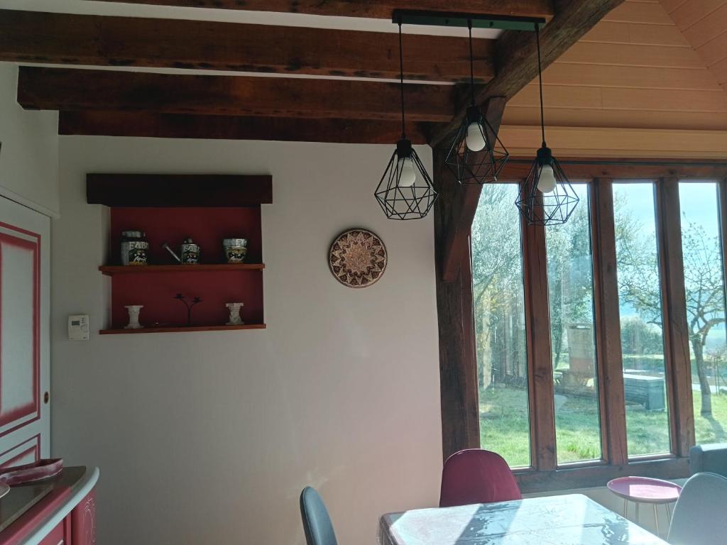 d'une salle à manger avec une table et quelques fenêtres. dans l'établissement GITE DU HOUSSAY, à Valennes