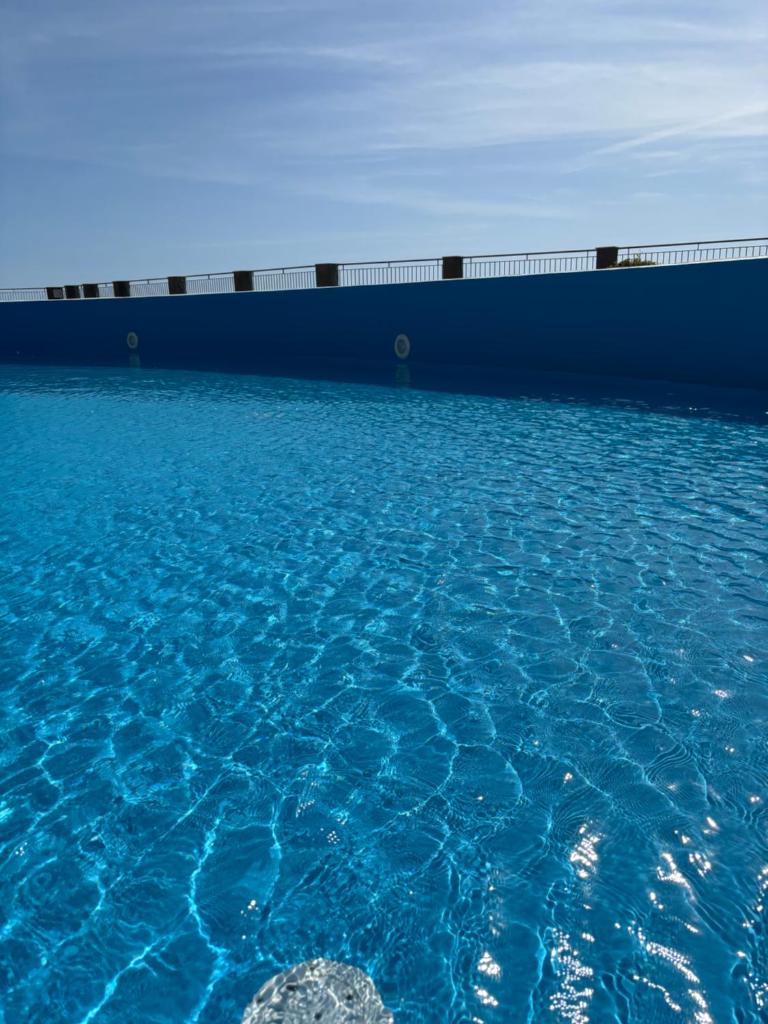 une grande piscine d'eau bleue avec dans l'établissement Casa faith, à Campionna