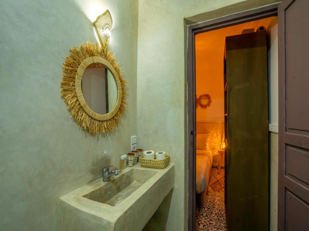 une salle de bain avec un lavabo et un miroir au mur dans l'établissement Riad Tarba & Spa, à Marrakech
