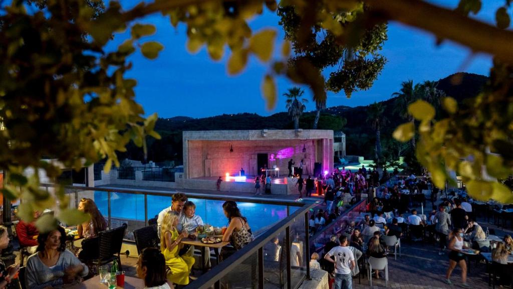 un groupe de personnes assises autour d'une piscine la nuit dans l'établissement Camping Tikayan Les Cigales - Maeva, au Muy 33 autres photos