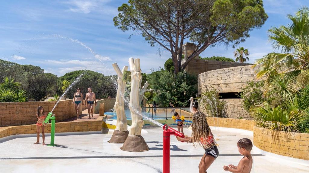 un groupe d'enfants jouant dans un parc aquatique dans l'établissement Camping Tikayan Les Cigales - Maeva, au Muy
