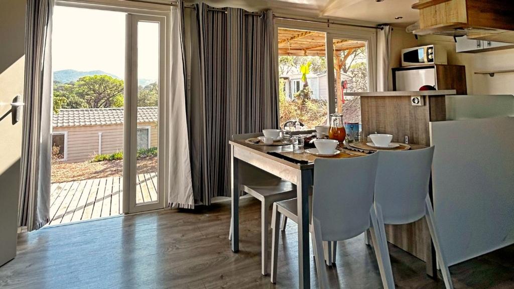 Il comprend une cuisine avec une table et des chaises. dans l'établissement Camping Tikayan Les Cigales - Maeva, au Muy