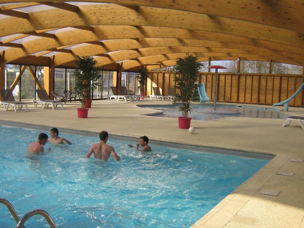 un groupe d'hommes nageant dans une piscine dans l'établissement Camping Le Tarteron, au Crotoy