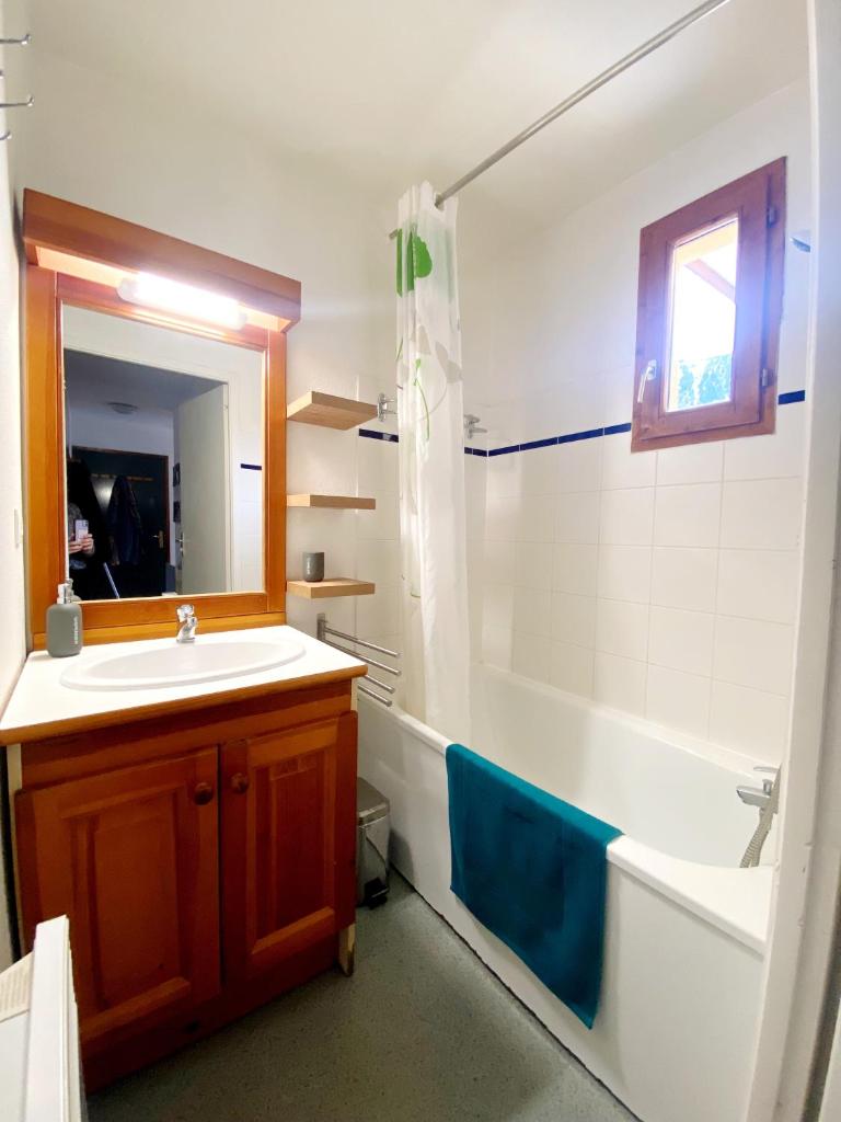 une salle de bain avec un lavabo, une baignoire et un miroir dans l'établissement Appartement Ski Pied de Pistes - Valfréjus, à Modane