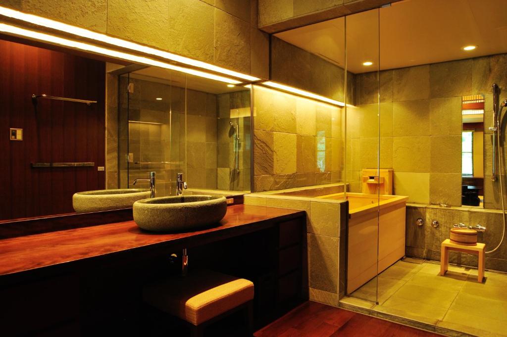une salle de bain avec un lavabo et un grand miroir dans l'établissement 竹泉荘 Chikusenso Onsen, à Zao 37 autres photos
