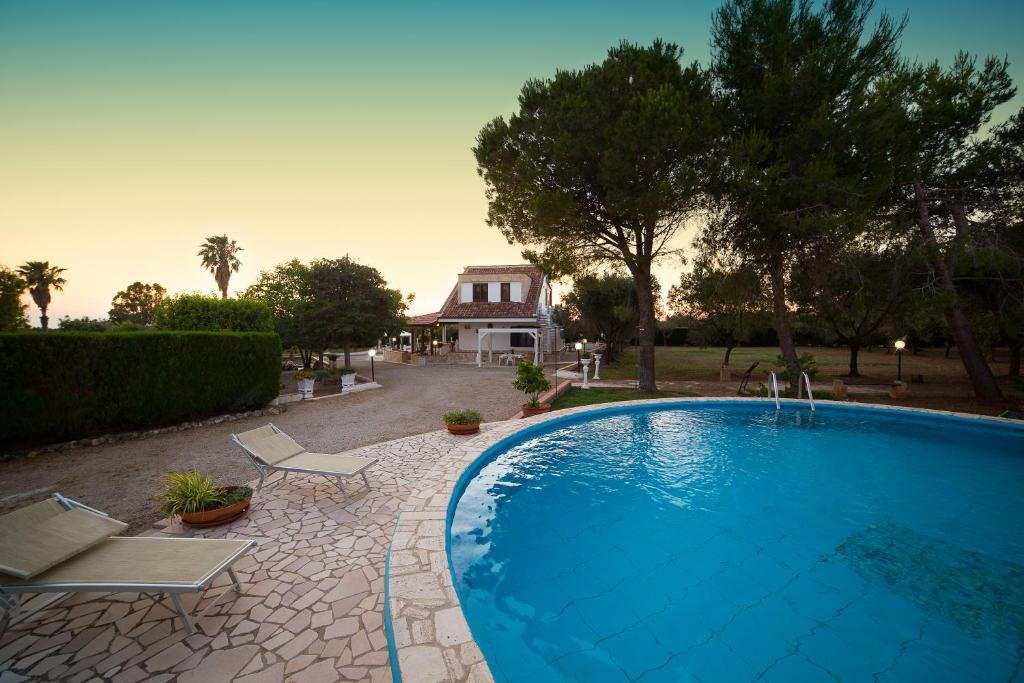 une piscine avec deux chaises et une maison dans l'établissement Villa dei Sogni Gallipoli, à Tuglie