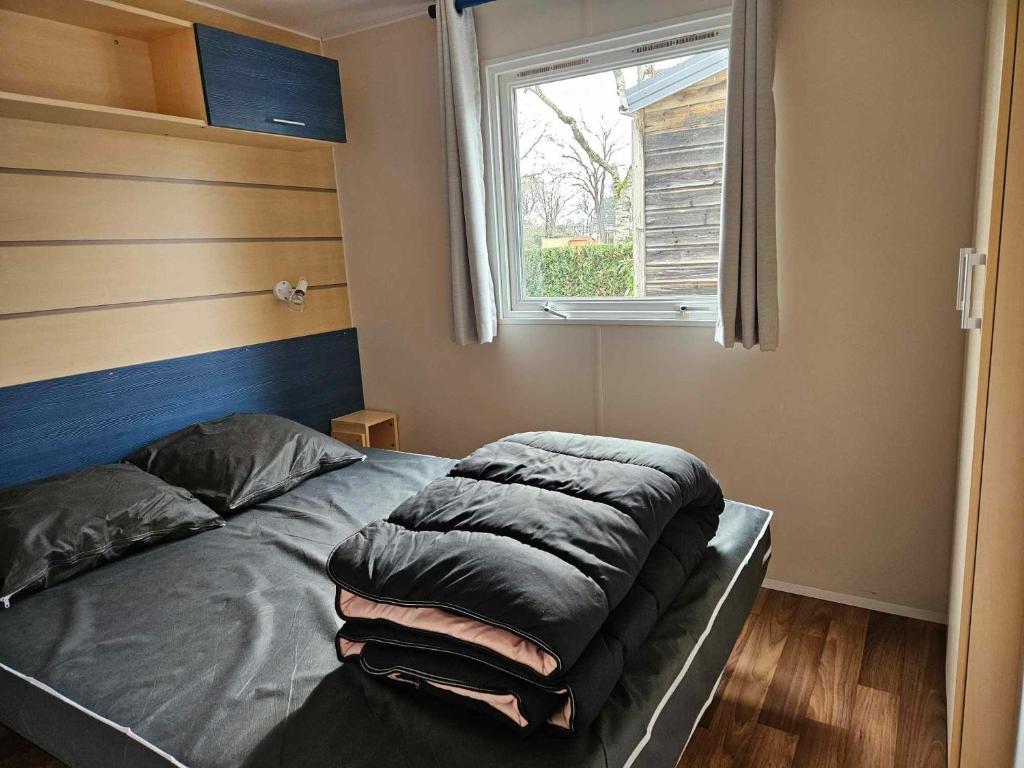 un lit dans une chambre avec une fenêtre dans l'établissement Mobil home 6 personnes Alsace, à Biesheim