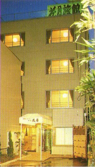 un grand bâtiment avec des lumières allumées devant lui dans l'établissement Kagetsu Ryokan, à Shizuoka