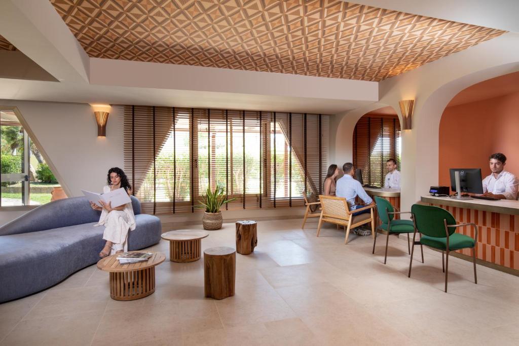 une femme assise sur un canapé dans un salon dans l'établissement VOI Tanka Selected, à Villasimius 40 autres photos