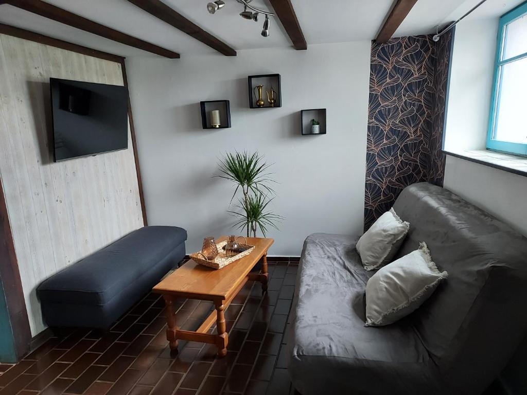 un salon avec un canapé et une table dans l'établissement Gites de la Janais, à Le Pin