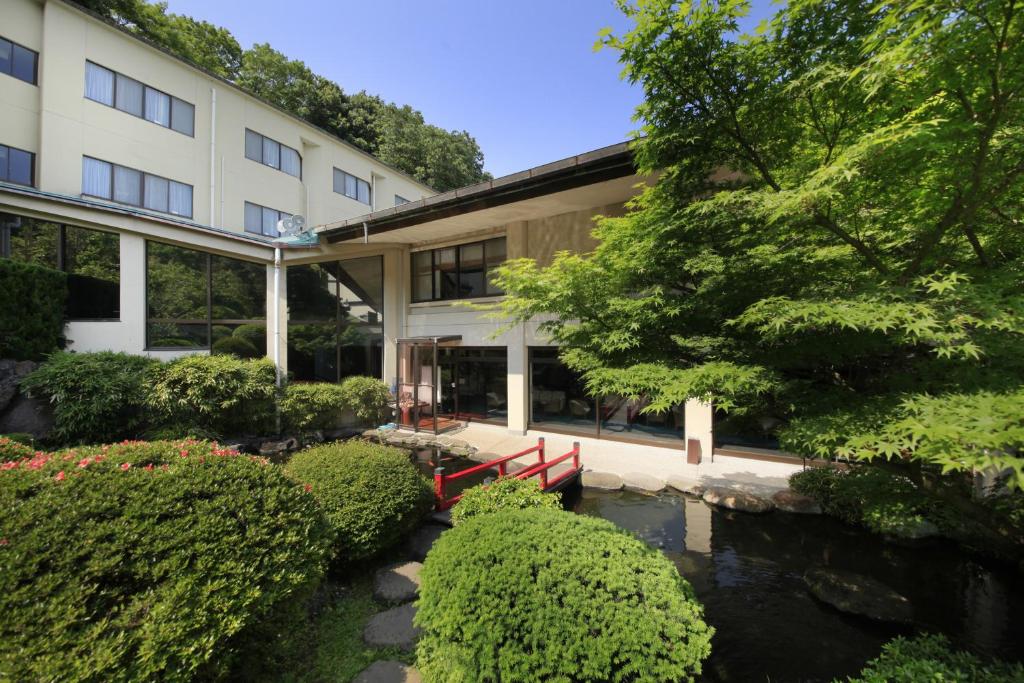 un bâtiment avec un étang devant dans l'établissement Izuajiro-onsen Shoufuen, à Atami