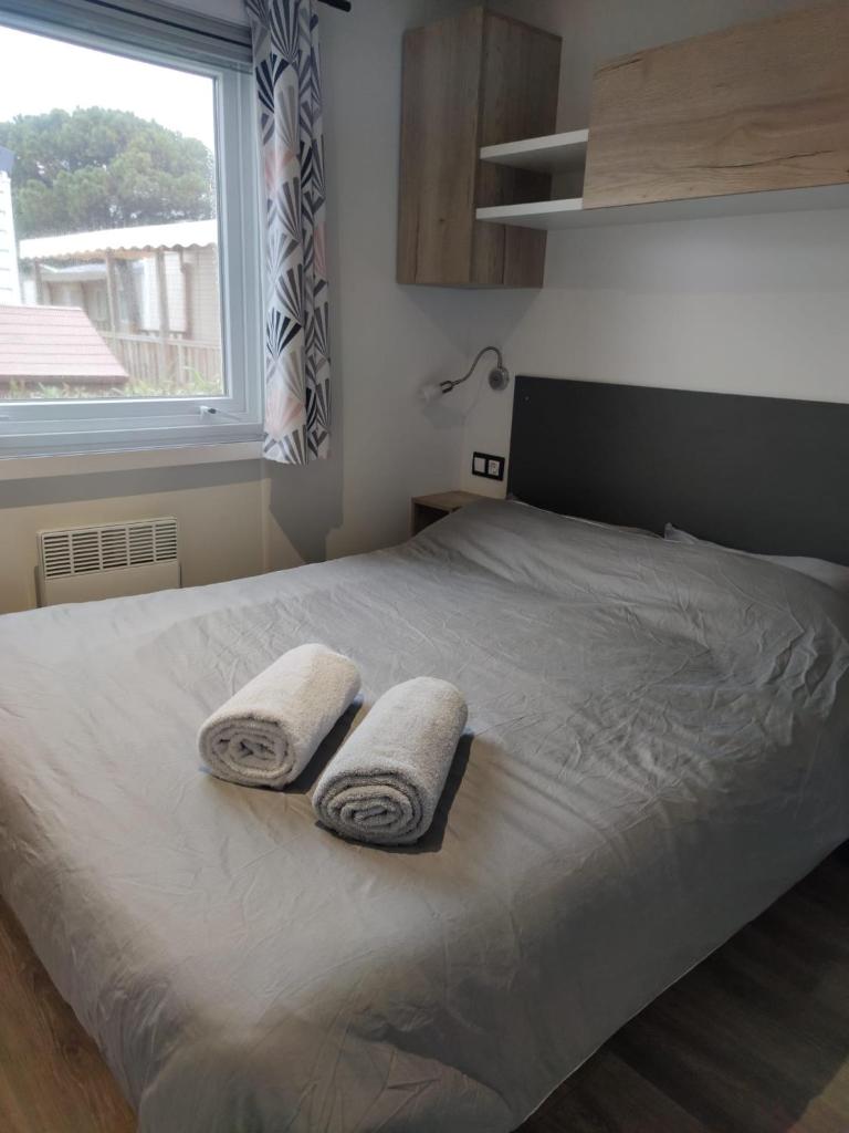 une chambre avec un lit avec deux serviettes dessus dans l'établissement Mobil home 3 chambres Accès direct plage 4 Etoiles, à Canet 1 autre photo