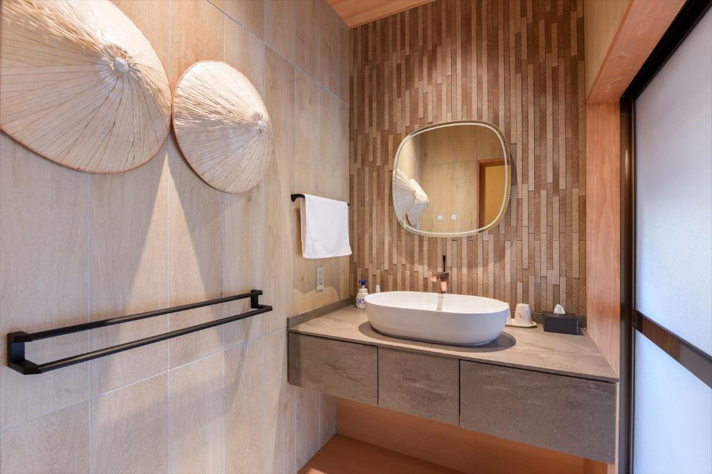 une salle de bain avec un lavabo et un miroir dans l'établissement Hanare Yado Yosizumi, à Itō