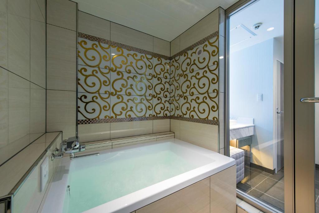 La salle de bains est pourvue d'une douche, d'une baignoire et d'une porte en verre. dans l'établissement HOTEL COSTA RESORT Omiya, à Saitama 33 autres photos