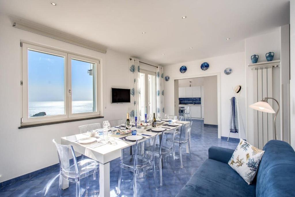 une salle à manger avec une table et un canapé bleu dans l'établissement Belvedere delle Sirene with Views Pool and Guest Services by Feeling Italy, à Colli di Fontanelle