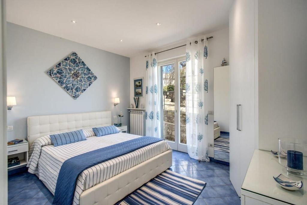 une chambre blanche avec un lit et une fenêtre dans l'établissement Belvedere delle Sirene with Views Pool and Guest Services by Feeling Italy, à Colli di Fontanelle