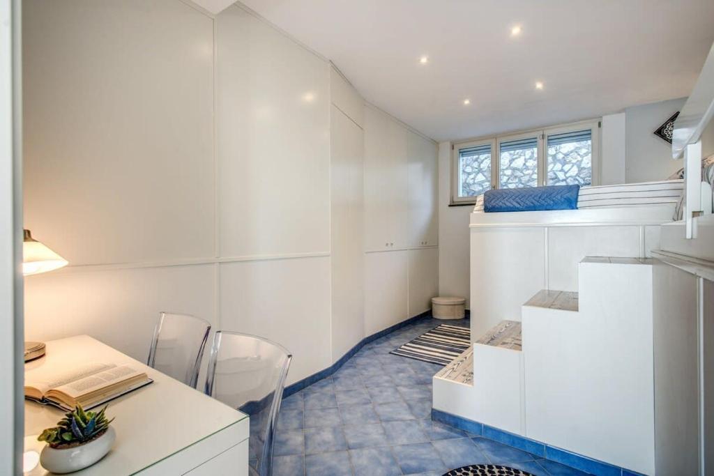 Cette petite chambre dispose d'un bureau, d'une table et d'un escalier. dans l'établissement Belvedere delle Sirene with Views Pool and Guest Services by Feeling Italy, à Colli di Fontanelle