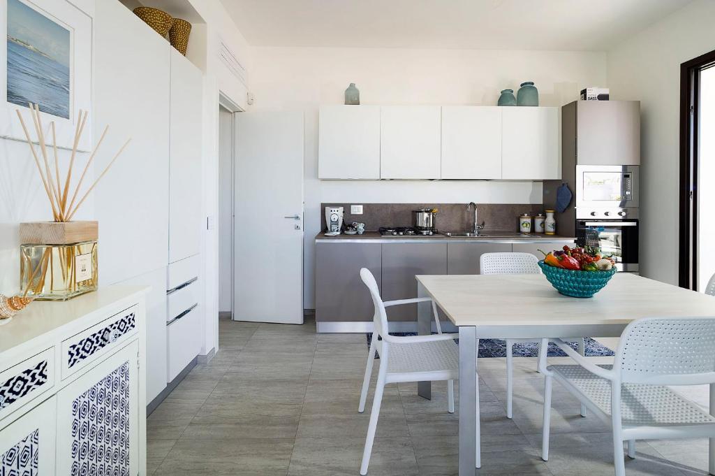 une cuisine blanche avec une table et des chaises dans l'établissement San Lorenzo - Rosmarino, à Reitani