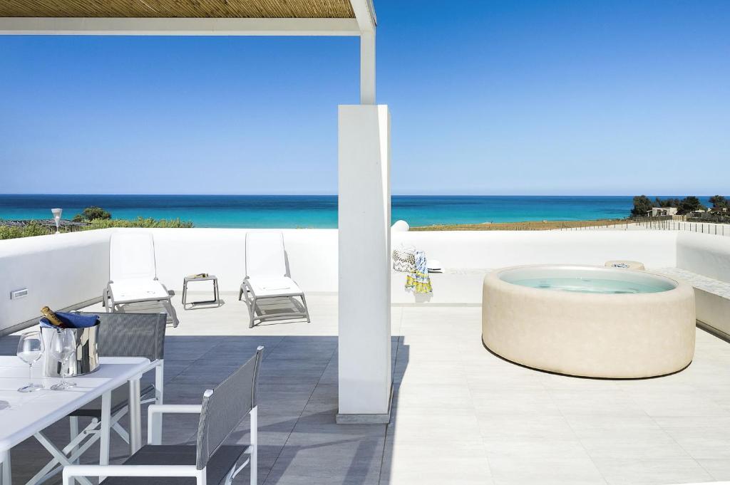 une terrasse avec un bain à remous et l'océan dans l'établissement San Lorenzo - Timo, à Reitani