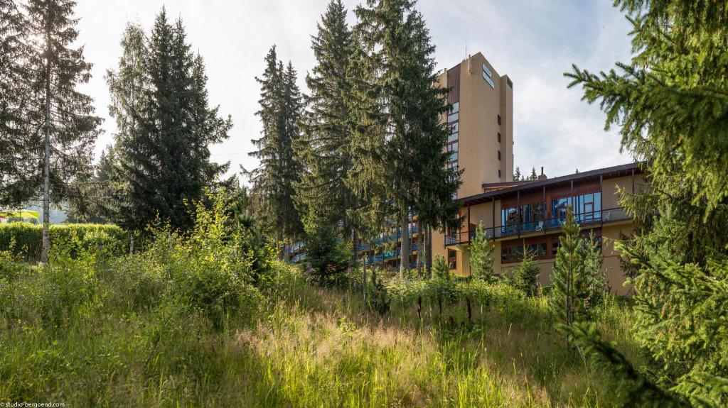 un bâtiment au milieu d'un champ avec des arbres dans l'établissement Résidence Pierre & Vacances Le Belmont, à Arc 1800