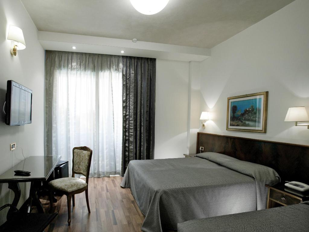 une chambre d'hôtel avec un lit, un bureau et une fenêtre dans l'établissement Hotel Ambasciatori, à Cesenatico 28 autres photos