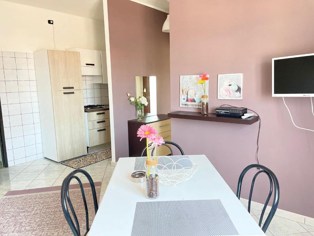 une salle à manger avec une table et des chaises blanches dans l'établissement Home Le Castella, à Le Castella