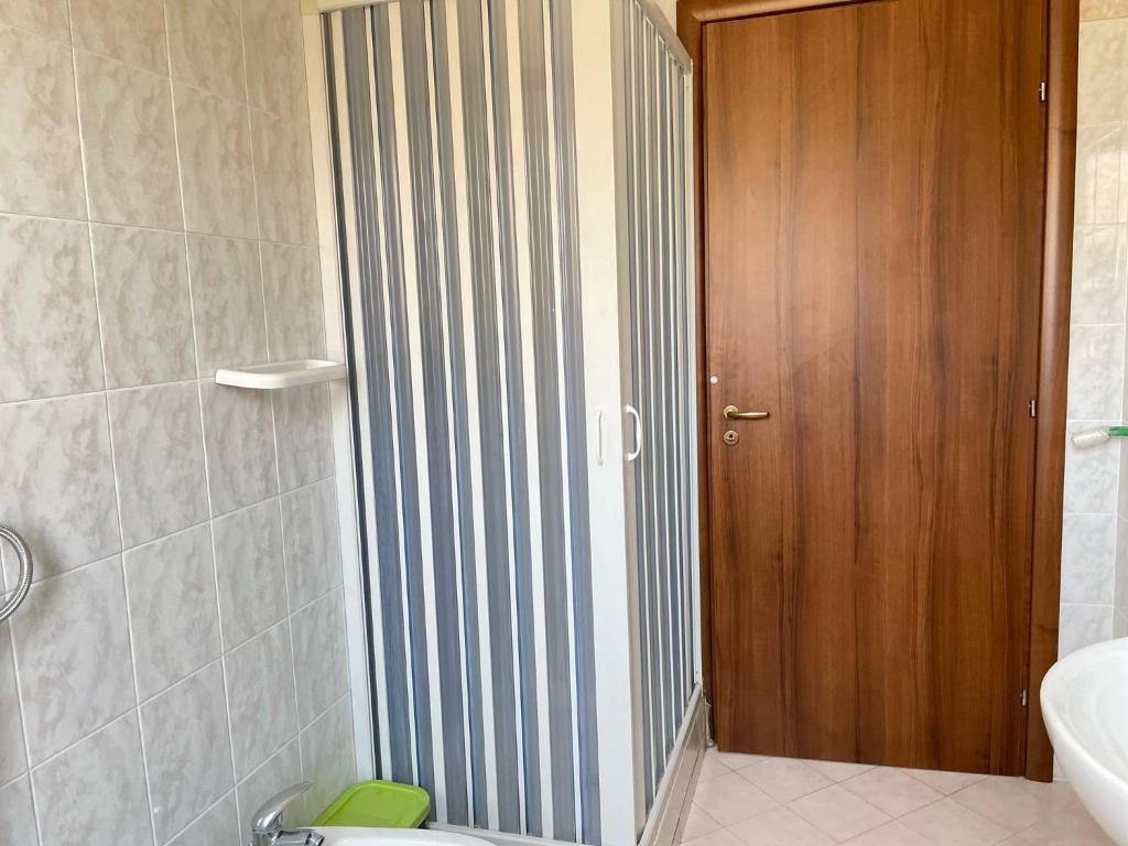 une salle de bain avec toilettes et porte en bois dans l'établissement Home Le Castella, à Le Castella