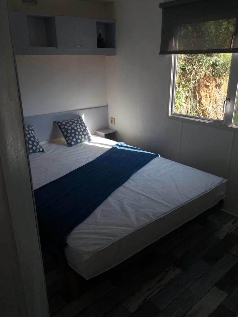 une chambre avec un grand lit avec une fenêtre dans l'établissement SAS CAMPING PARC MONTANA, à Gassin