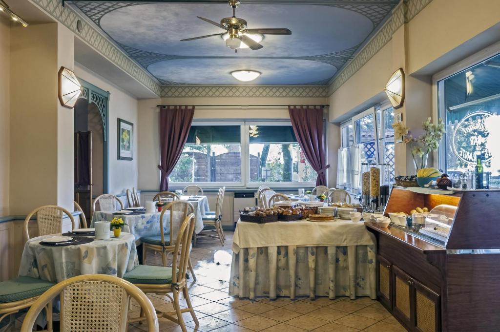 une salle à manger avec tables et chaises et un plafond dans l'établissement Hotel Kursaal, à Passignano sul Trasimeno