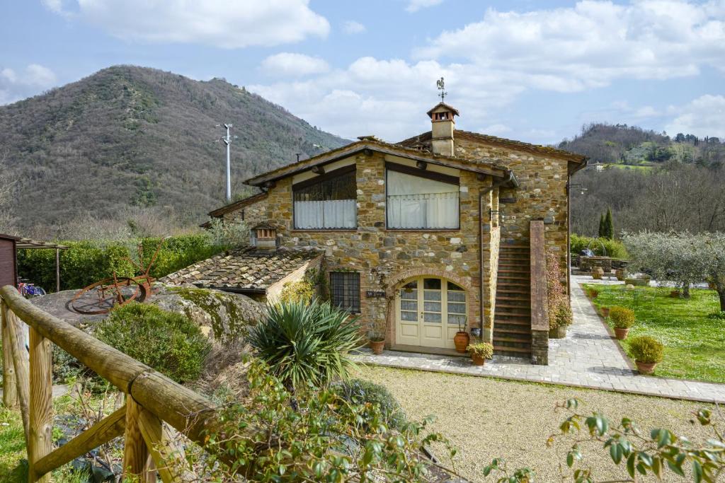 une maison en pierre avec une montagne en arrière-plan dans l'établissement Villa Dani by Mmega, à Lucques