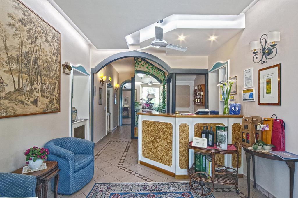 un salon avec un comptoir et une chaise bleue dans l'établissement Hotel Kursaal, à Passignano sul Trasimeno