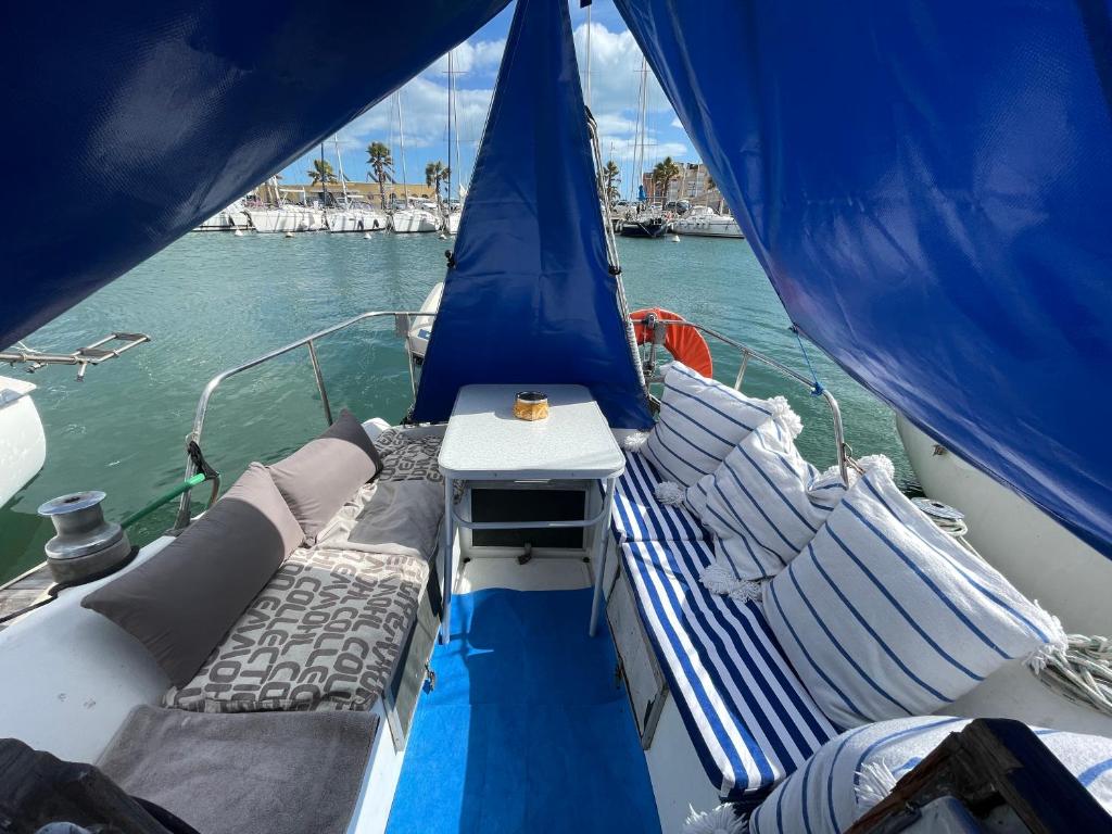 un bateau avec un lit et une table sur un bateau dans l'établissement Symbiose sur l’eau Gruissan, à Gruissan