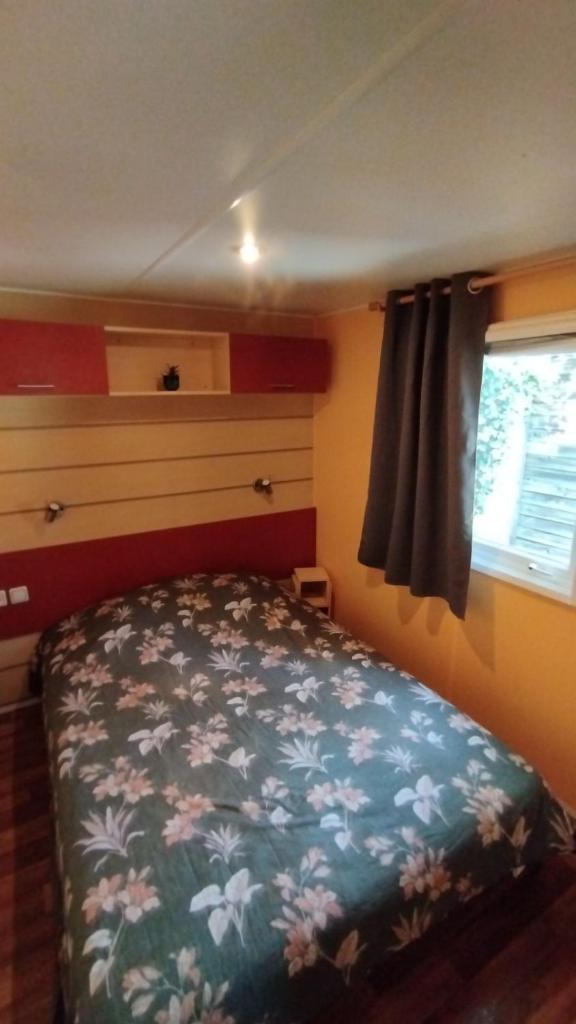 une chambre avec un lit et une fenêtre dans l'établissement Charmant Mobil Home 6 personnes avec clim réversible, à Boofzheim