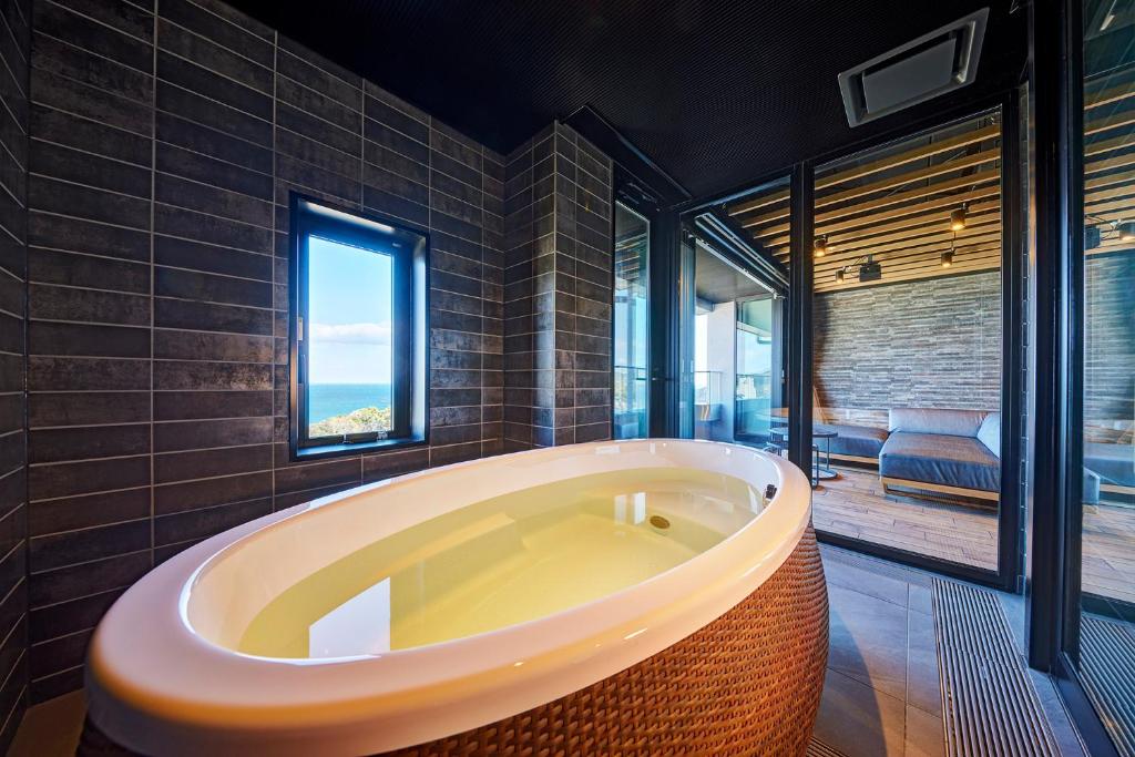 Cette chambre comprend une salle de bains pourvue d'une grande baignoire. dans l'établissement Resort Hills Toyohama Soranokaze, à Toba
