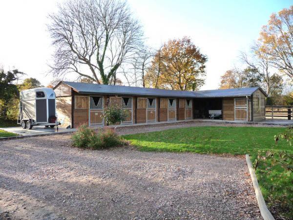 une grande maison avec un parking dans une cour dans l'établissement la Pomone, à Blonville-sur-Mer