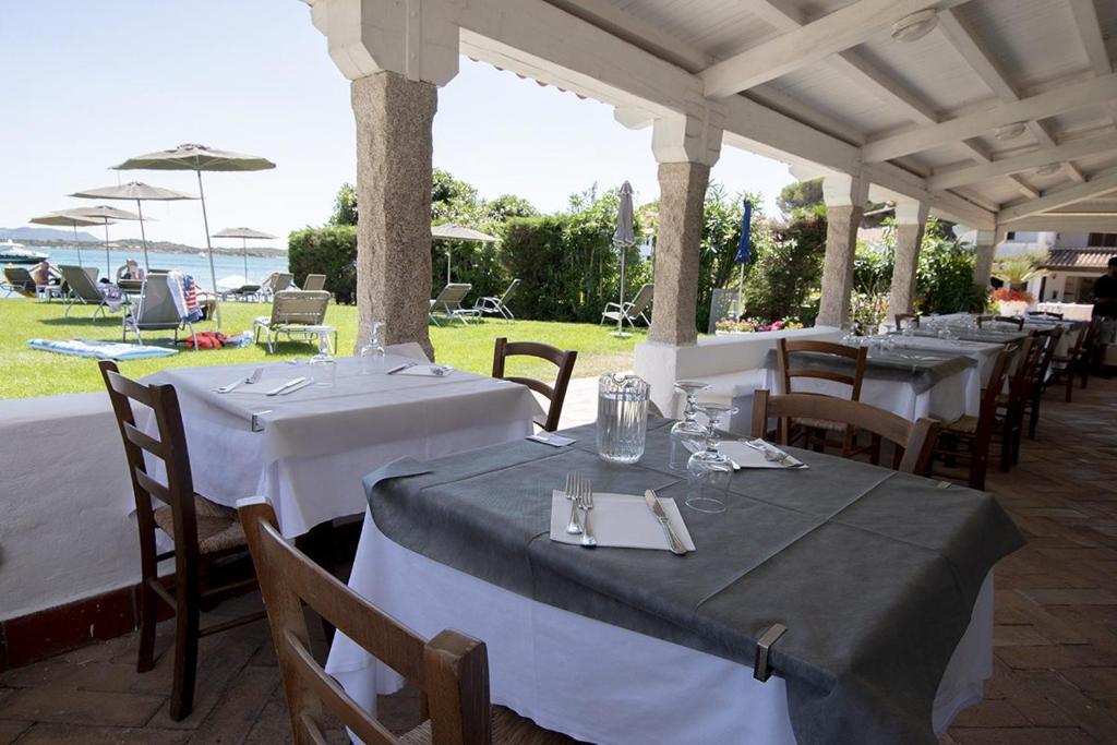 une rangée de tables et de chaises sous un pavillon dans l'établissement IHR Hotel San Paolo, à Porto San Paolo 70 autres photos