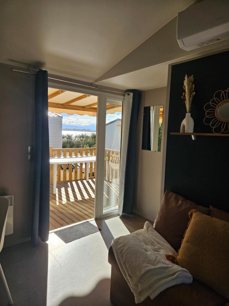 d'un salon avec une porte coulissante en verre menant à une terrasse. dans l'établissement Casa Luisa Mobil Home, à Canet