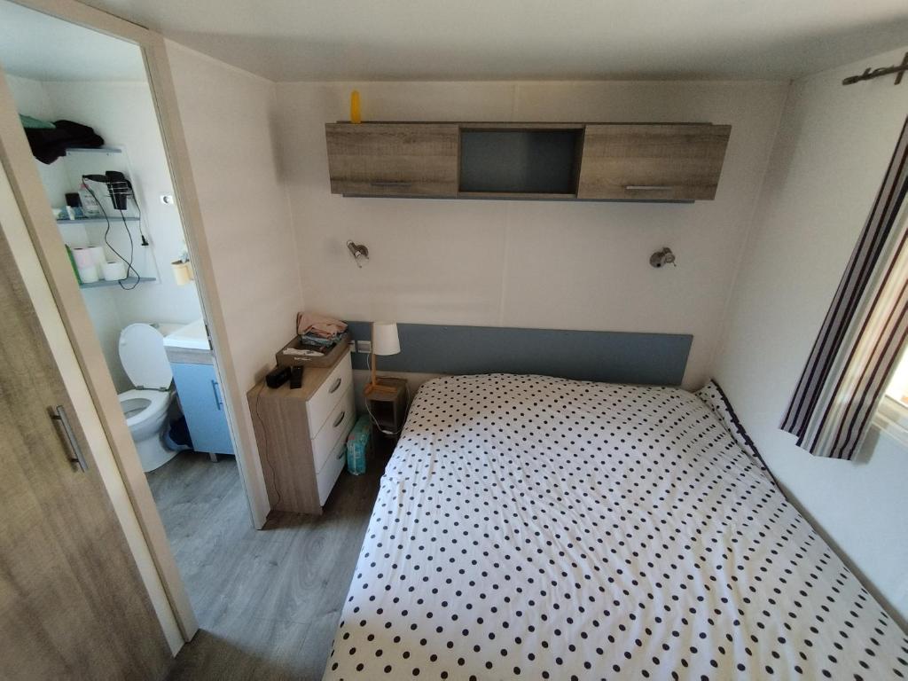 - une petite chambre avec un lit et une salle de bains dans l'établissement Mobil home à louer dans camping des cigales le muy 5 étoiles, au Muy