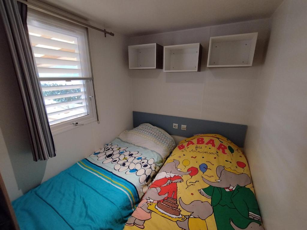 une petite chambre avec un lit et une fenêtre dans l'établissement Mobil home à louer dans camping des cigales le muy 5 étoiles, au Muy