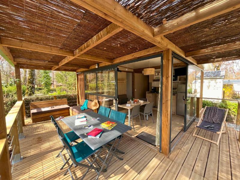 un patio avec une table et des chaises sur une terrasse dans l'établissement Camping le Relais du Léman, à Messery