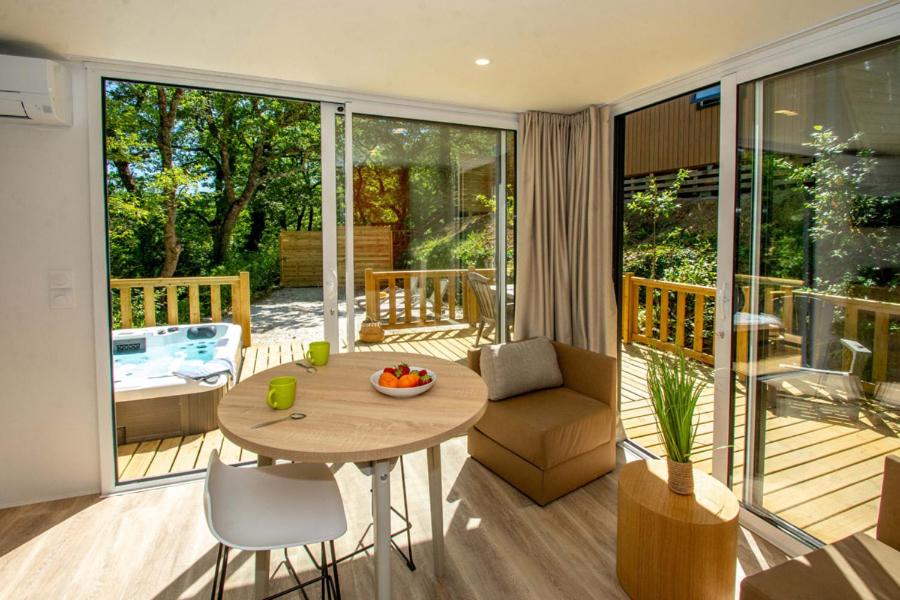 un salon avec une table et une terrasse dans l'établissement Camping Le Luberon, à Apt