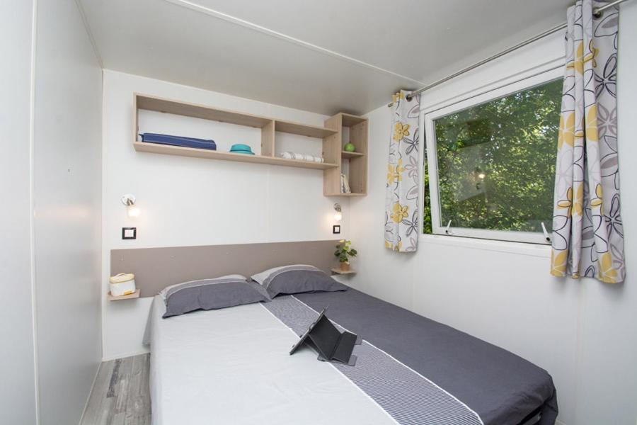 une chambre avec un lit et une fenêtre dans l'établissement Camping Le Luberon, à Apt