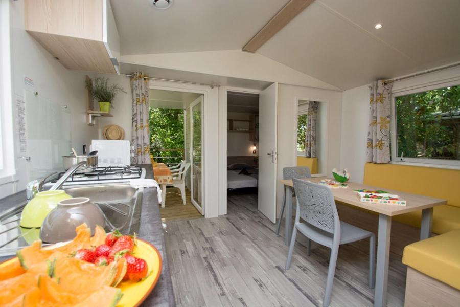 une cuisine et un salon avec une table et une assiette de nourriture dans l'établissement Camping Le Luberon, à Apt 34 autres photos