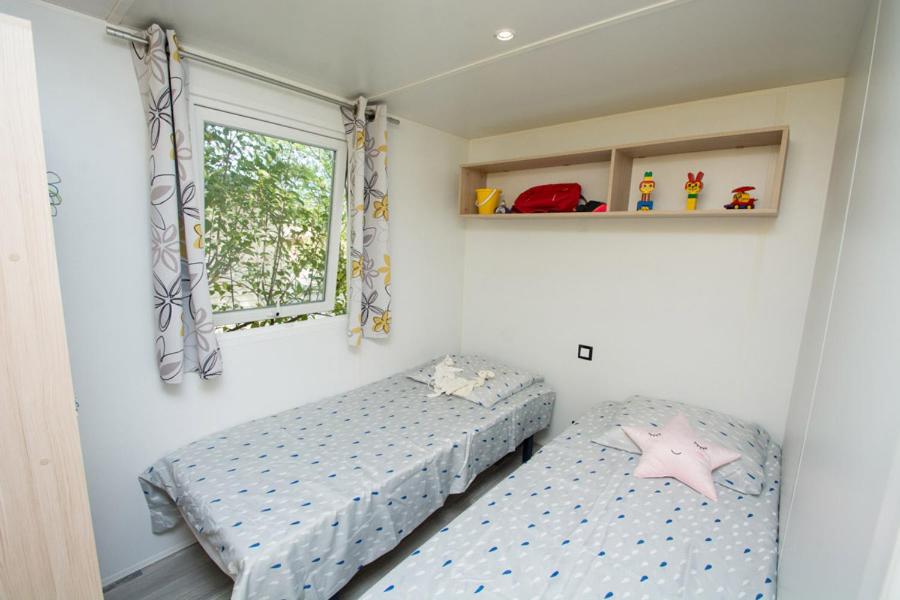 une chambre avec deux lits et une fenêtre dans l'établissement Camping Le Luberon, à Apt