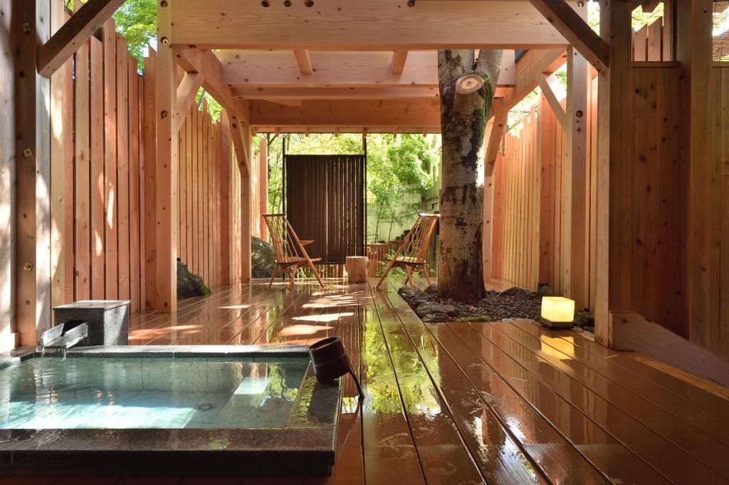 une baignoire jacuzzi dans une maison avec un arbre dans l'établissement Syoubun, à Minakami